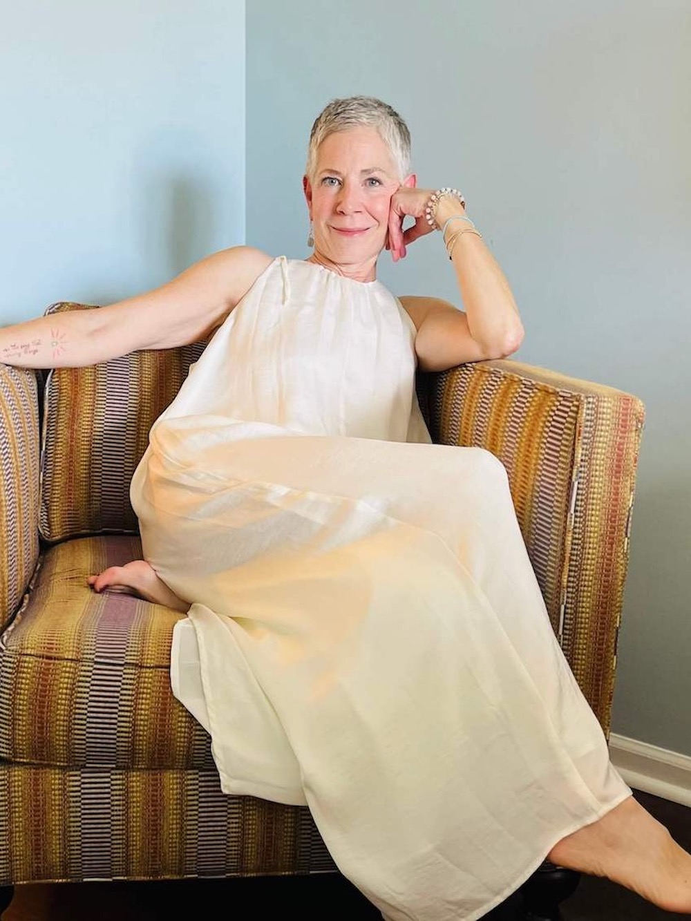 image of Gina Neely sitting on chair wearing white dress