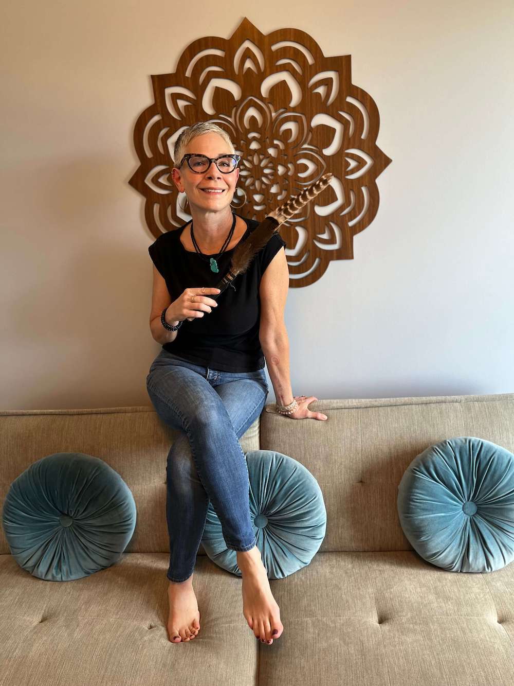 image of Gina Neely sitting on couch holding feathers